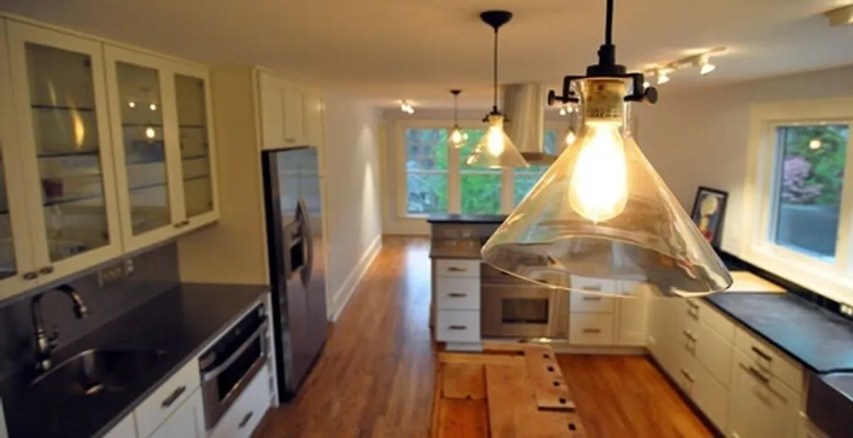 Residential electrician installing modern indoor light fixture in a home in Dallas, TX